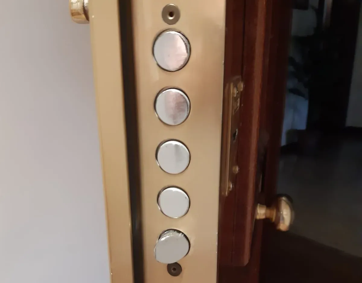 Canto de una puerta acorazada abierta, con los bulones de acero de su sistema de cierre.