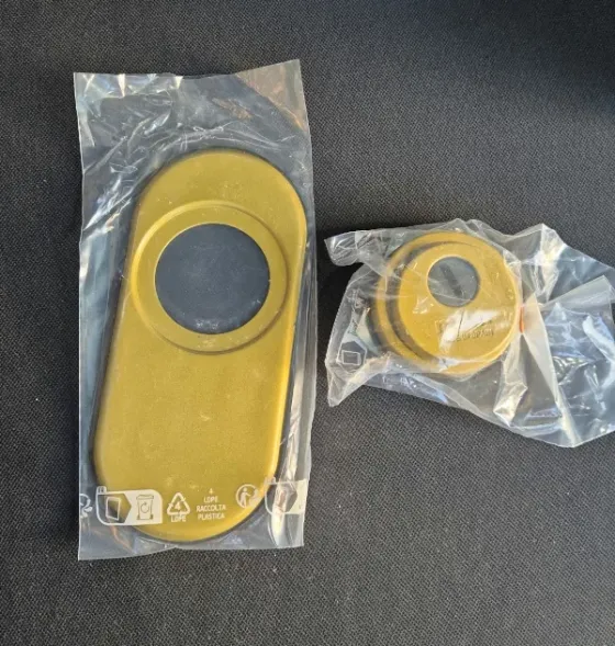 Escudos protectores de latón de un cerrojo de seguridad, dentro de su embalaje.